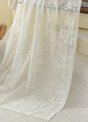 a white sheer curtain hanging from the side of a window