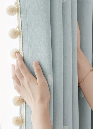 a woman's hand on the curtain of a window