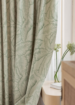 a bedroom with a bed and a window with a curtain