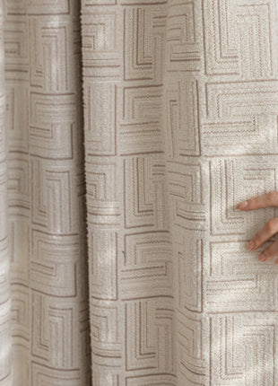 a woman holding onto a curtain with her hand