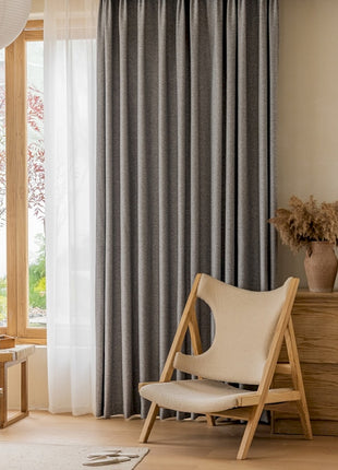 a living room with a chair and a window