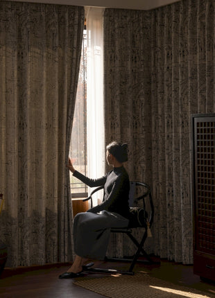 a woman sitting in a chair in front of a window