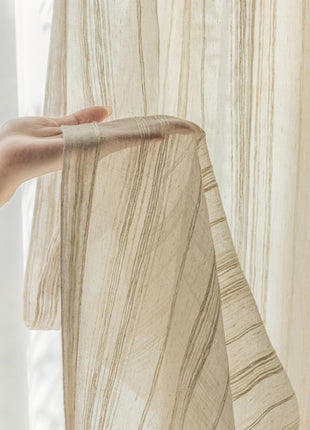 a person's hand is holding a curtain in front of a window