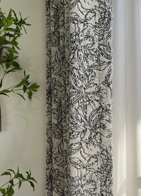 a plant is hanging on a wall next to a curtain