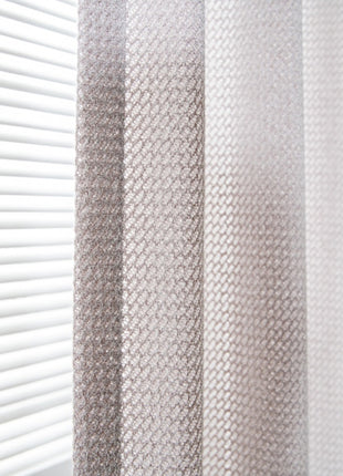 a close up of a curtain with a window in the background