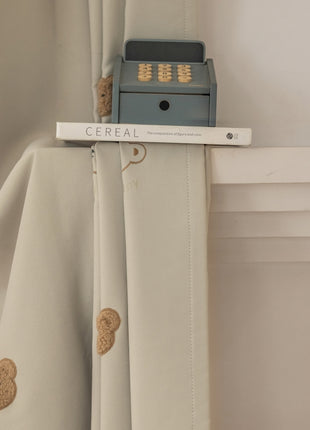 a close up of a curtain with a teddy bear on it