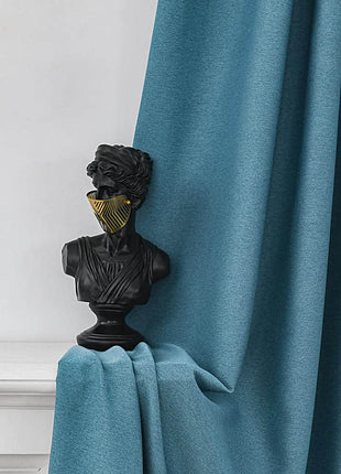 a statue of a man is on a curtain rod
