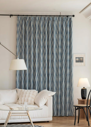 a living room with a white couch and a blue curtain