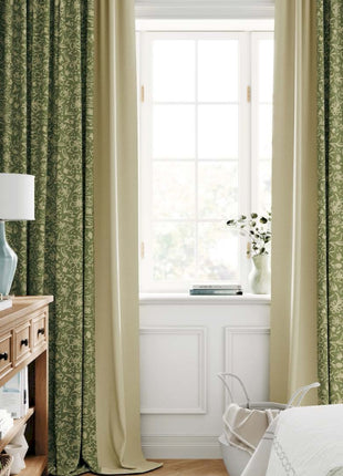 a bedroom with green curtains and a white bed