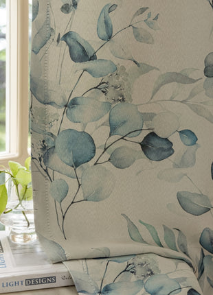 a window with a blue flowered curtain next to a stack of books