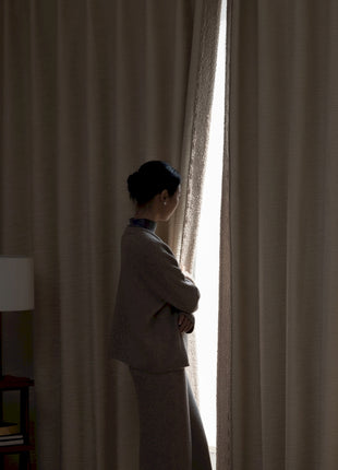 a woman standing in front of a window