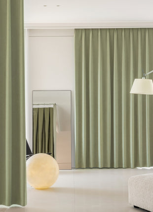 a living room with green curtains and a white couch