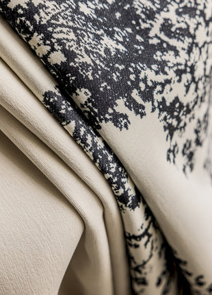 a close up of a black and white pillow on a chair