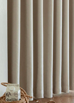 a bag of oats sitting on the floor next to a curtain