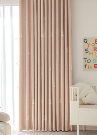 a baby's room with a white crib and pink curtains