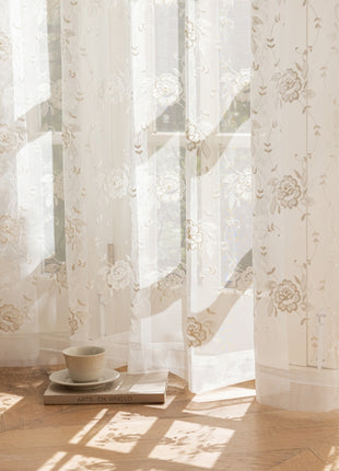 a cup and saucer sitting on a table in front of a window