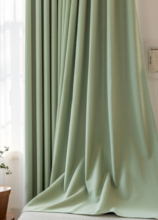 a green curtain is hanging in front of a window