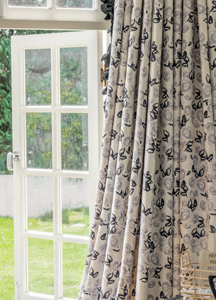 a window with a curtain and a chair in front of it