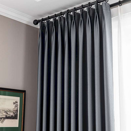 a window with a black curtain and a picture on the wall