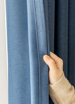 a person is opening the curtain with their hand