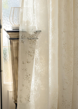 a window with a white curtain and a basket on top of it