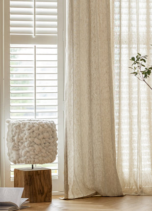 a white vase with a plant in it next to a window