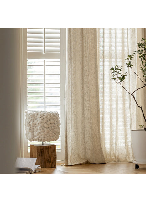 a white vase with a plant in it next to a window