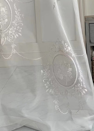 a white curtain with a design on it