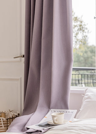 a bed with a book and a cup on top of it