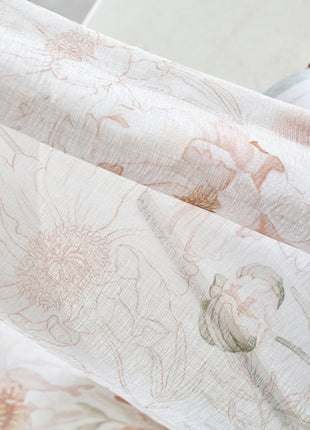 a close up of a flowered fabric with a book in the background