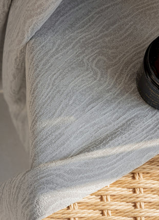a bottle of lotion sitting on top of a bed