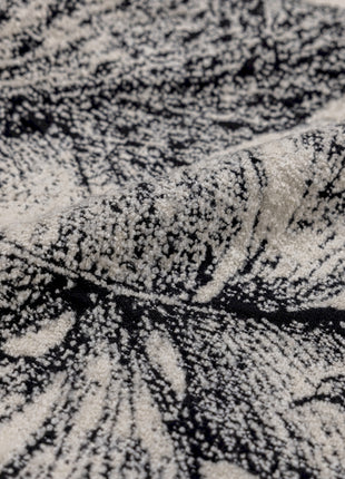 a black and white rug with a leaf pattern