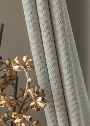 a close up of a flower near a curtain