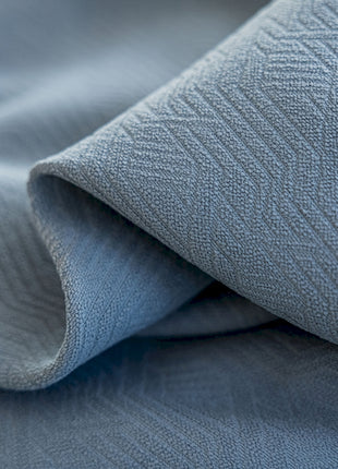 a close up of a bed with a blue comforter