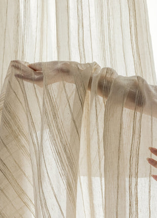 a woman's hand reaching out from behind a sheer curtain