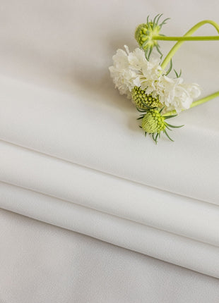 a close up of a white sheet with flowers on it