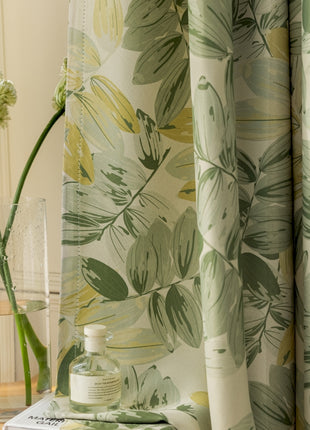 a vase of flowers sitting on a table next to a curtain