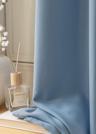 a bottle of perfume sitting on top of a table next to a vase