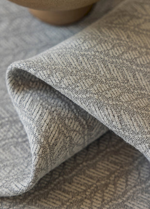 a close up of a cloth with a bowl in the background