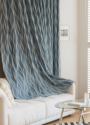 a living room with a white couch and a blue curtain