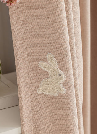 a close up of a curtain with a bunny embroidered on it