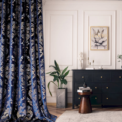 a living room with a black dresser and a blue curtain