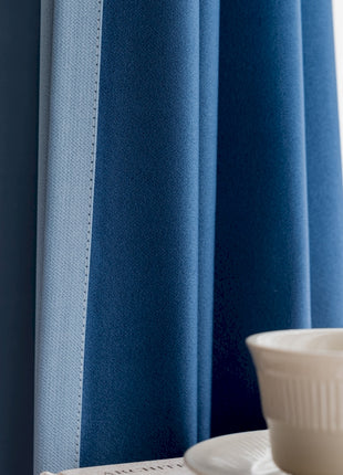 a cup and saucer on a table in front of a blue curtain