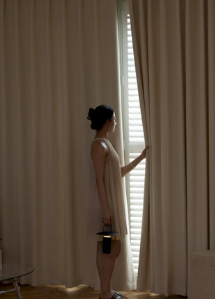 a woman standing in front of a window