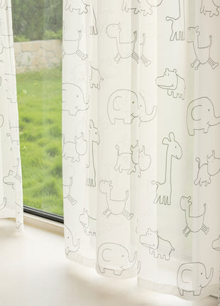 a window with a curtain that has drawings on it