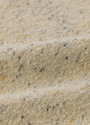 a close up of a white blanket with blue and yellow speckles