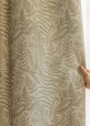 a person holding a curtain with a plant pattern on it