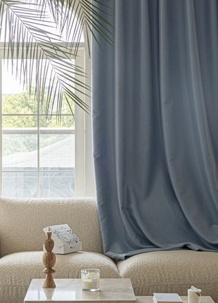 a living room with a white couch and a blue curtain