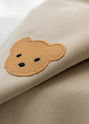 a close up of a pillow with a teddy bear on it