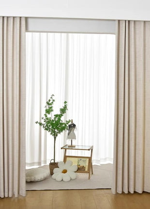 a living room with a large window and a plant in the corner